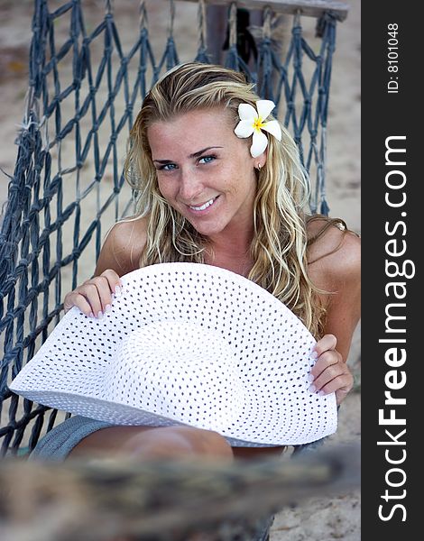 Happy girl with white hat sitting in hammock. Happy girl with white hat sitting in hammock