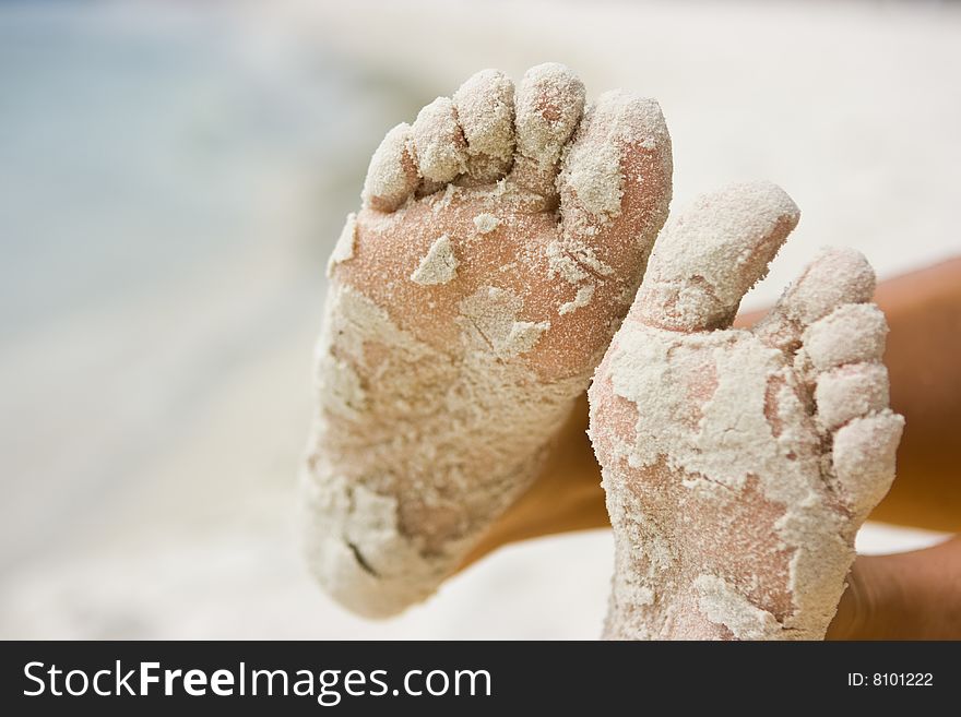 Female feet covered with sand completely. Female feet covered with sand completely