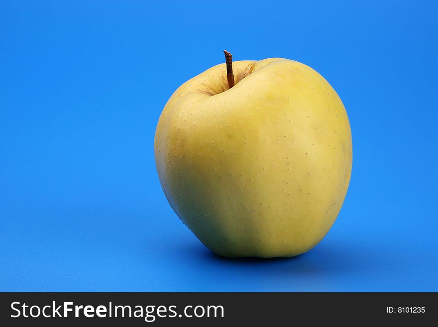 Yellow apple on a blue background