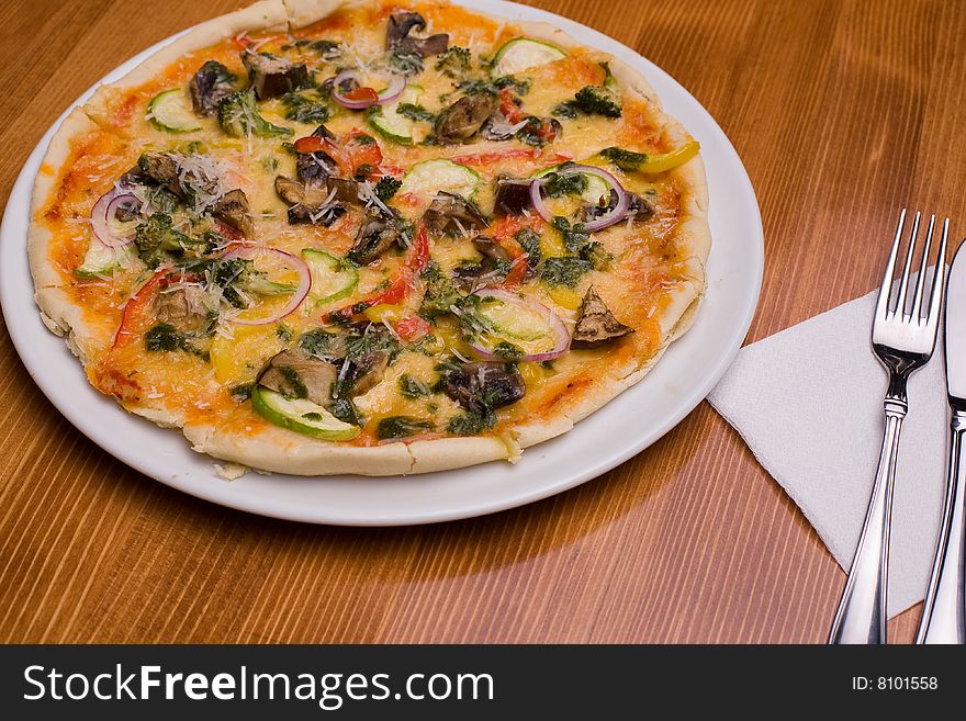 Pizza with vegetables on wooden background