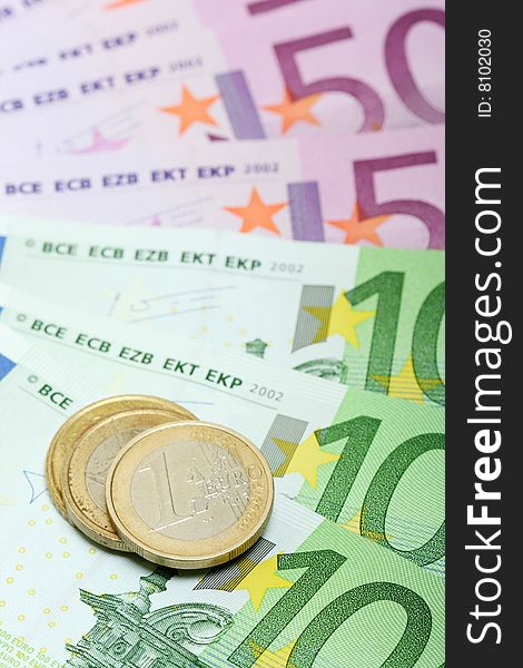 Euro banknotes with various coins