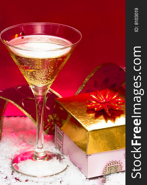 Glass with champagne and gift box