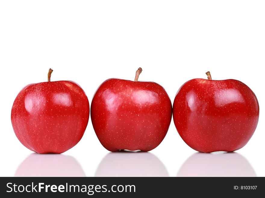 Three shiny red apples in a row isolated on white