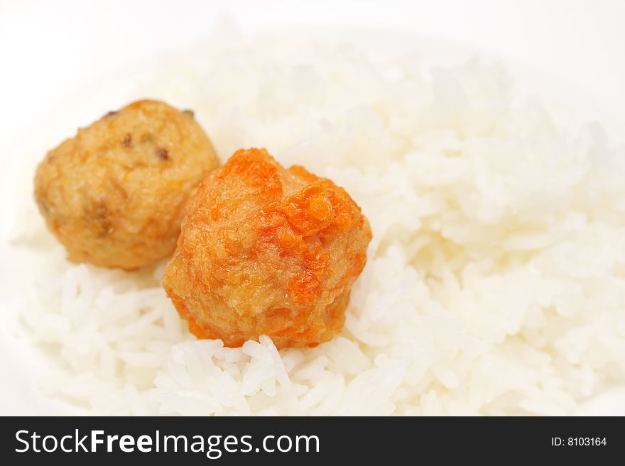 Two meat balls put on top of white rice. Two meat balls put on top of white rice.