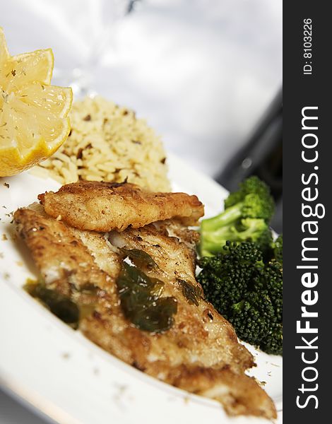 Fish meal with selective focus and wine bootle and glass in the background. Fish meal with selective focus and wine bootle and glass in the background