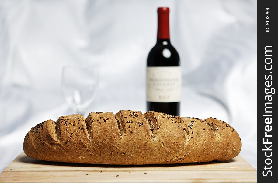 Fresh bread baked with soft backgrounf of wine and glass. Fresh bread baked with soft backgrounf of wine and glass