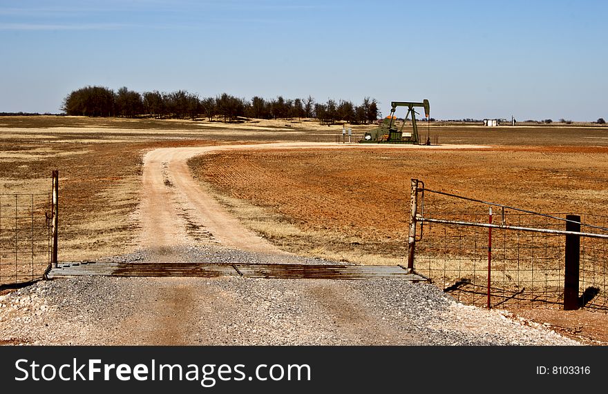 Dirt road leading up to an oil well. Dirt road leading up to an oil well