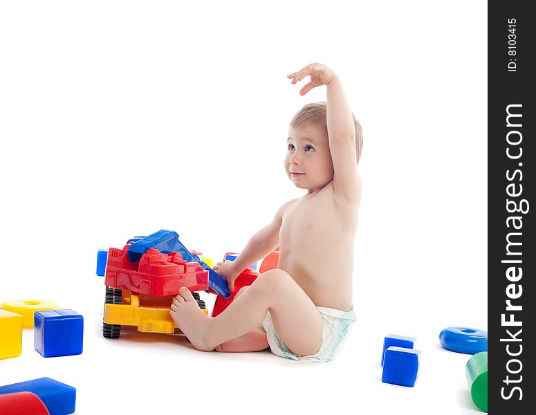 Little boy play with toys over white background with light shadows. Little boy play with toys over white background with light shadows.