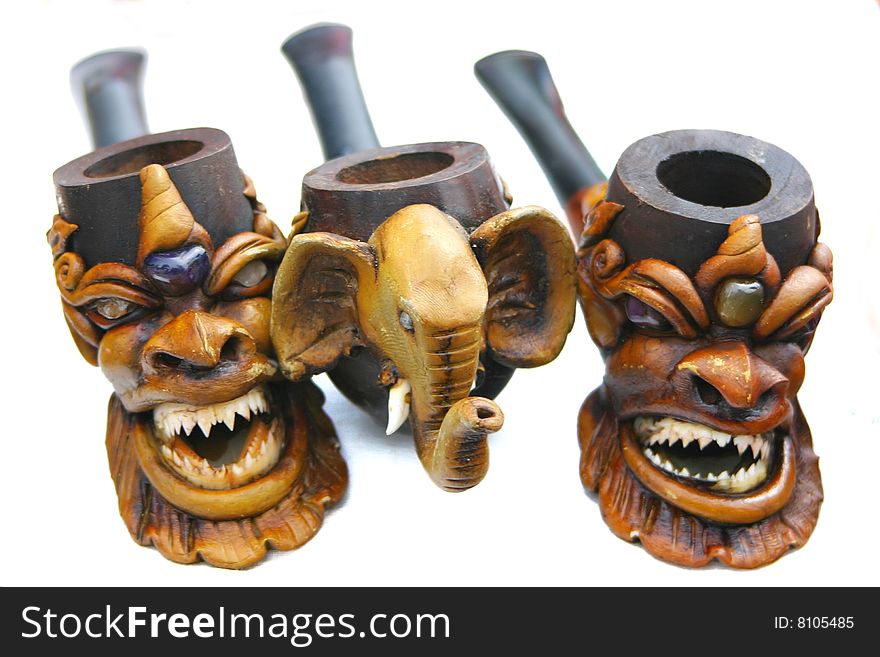 Hand carved wooden pipes on white background.