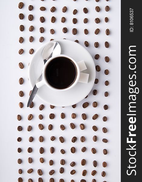 Coffe cup and lines of grains on the white surface. Coffe cup and lines of grains on the white surface