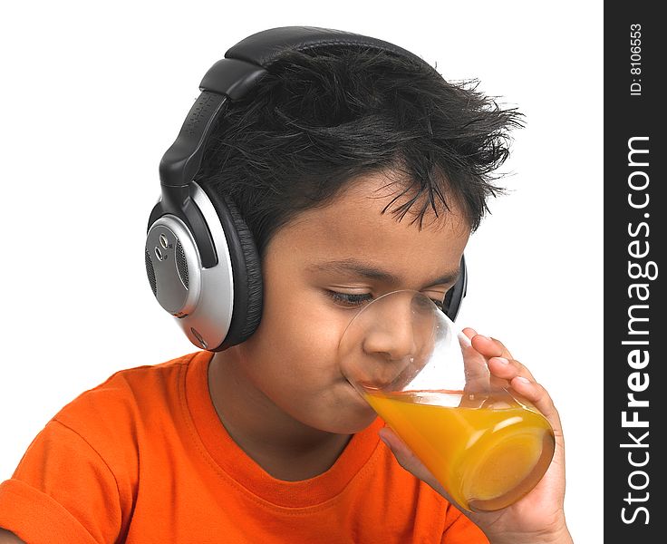 A cute asian boy drinking orange juice with his headphones on. A cute asian boy drinking orange juice with his headphones on
