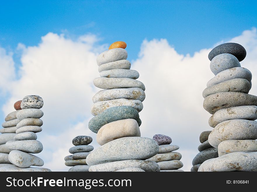 Piles from a sea pebble against the summer sky. Piles from a sea pebble against the summer sky