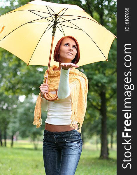 Beautiful young girl under yellow umbrella