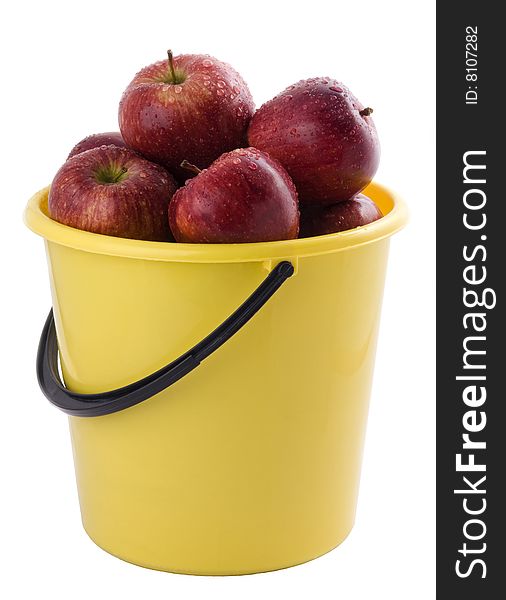 Red apples in a yellow bucket, isolated on white background.