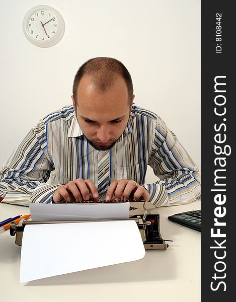 Man typing a document on an antique typewriter in an office. Man typing a document on an antique typewriter in an office