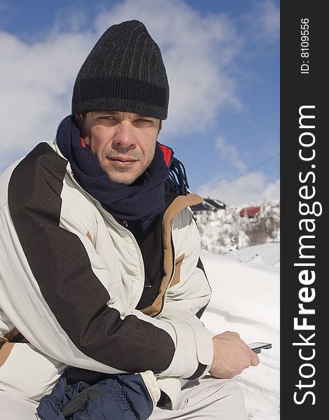 Man holding a mobile phone at a snow park. Man holding a mobile phone at a snow park