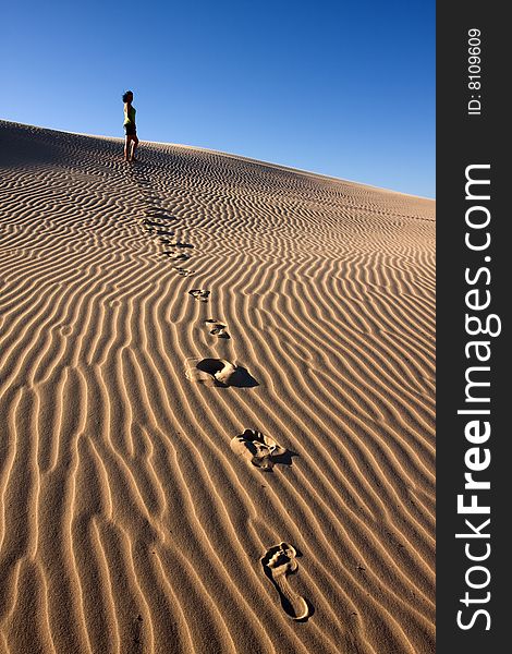 Young girl is walking in the Stockton dunes in Anna Bay, NSW, Australia. Young girl is walking in the Stockton dunes in Anna Bay, NSW, Australia.