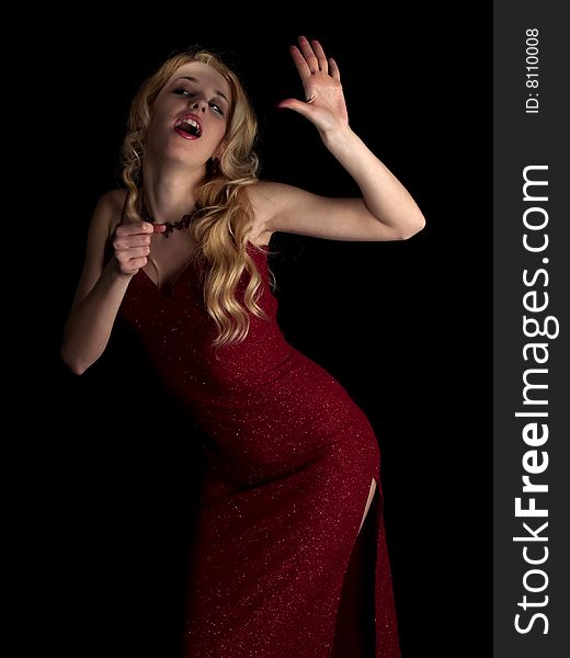 Beautiful blonde young lady in red dress singing. Beautiful blonde young lady in red dress singing