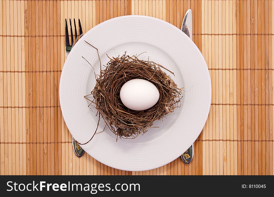Chicken egg in a nest served on a plate