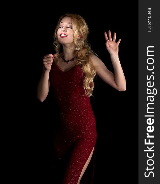 Beautiful blonde young lady in red dress singing. Beautiful blonde young lady in red dress singing