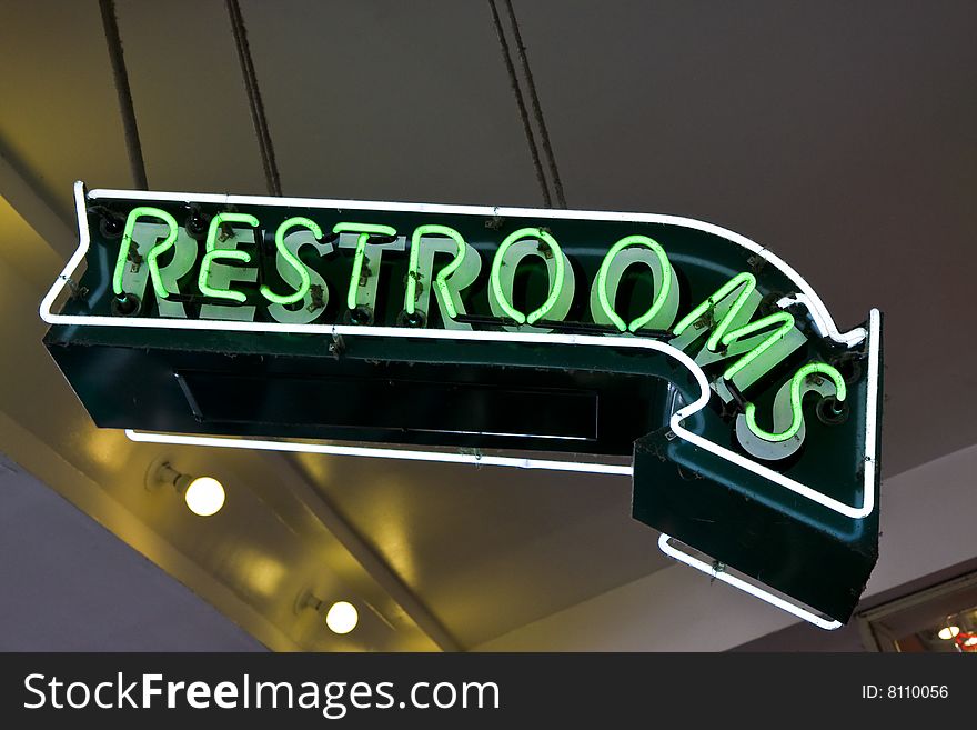 A bright green sign showing Restrooms downstairs. A bright green sign showing Restrooms downstairs