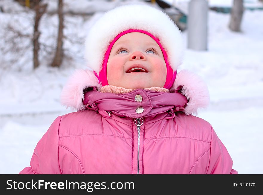 Pretty little girl in winter outerwear -  look up. Pretty little girl in winter outerwear -  look up.