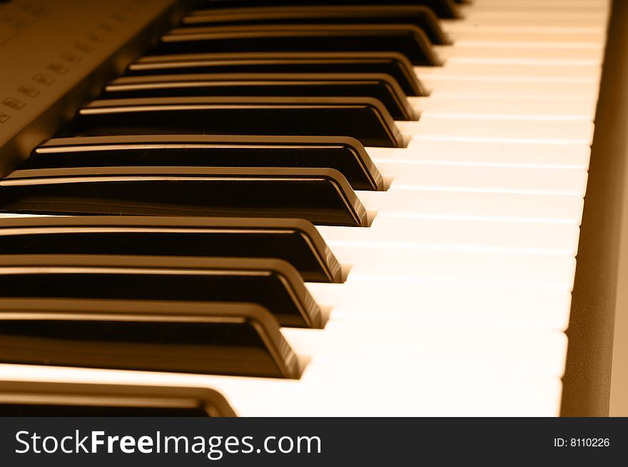 Closeup shoot of piano keyboard with orange tone