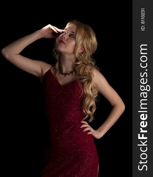 Beautiful blonde young lady in red dress on black background. Beautiful blonde young lady in red dress on black background