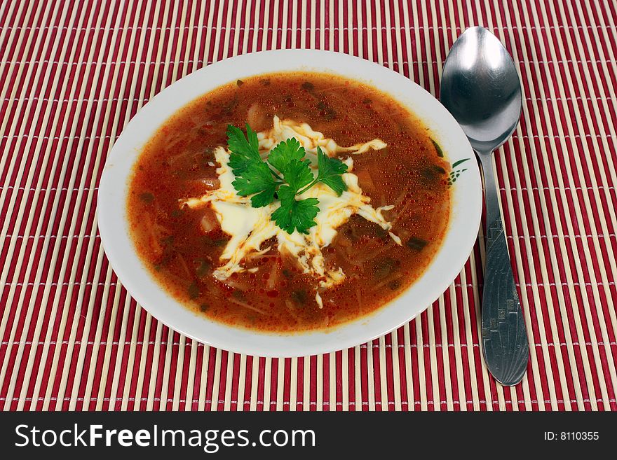 Delicious borsch with parsley and sour cream in a dish