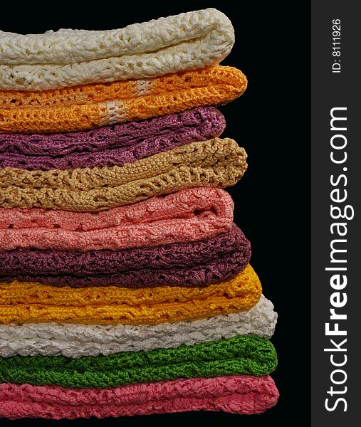 Stack of colored handmade jackets on the black background. Stack of colored handmade jackets on the black background
