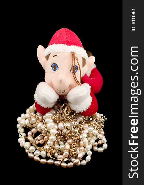 The gnome protecting gold with pearls isolated on black