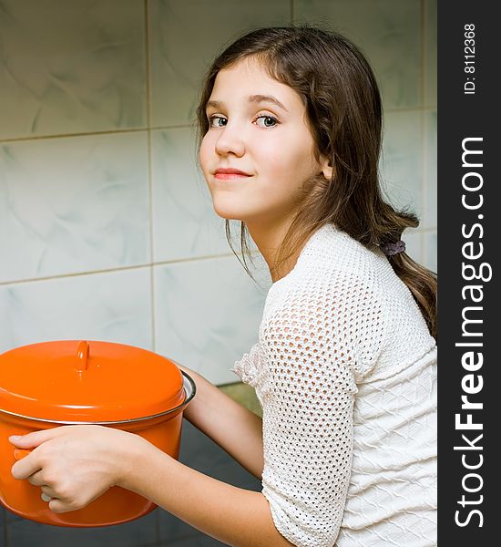 Teen girl with pan in kitchen