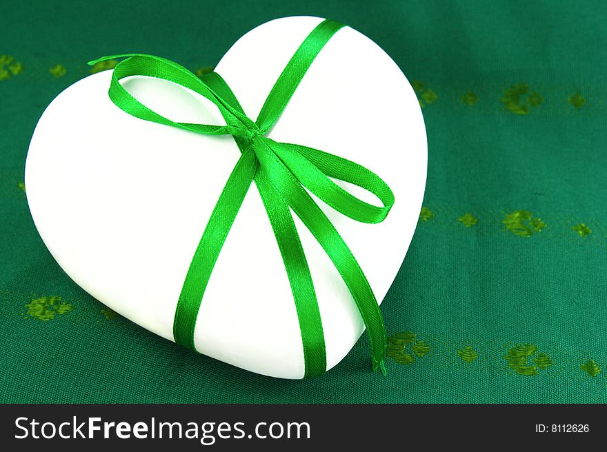 White heart with green tape on green background