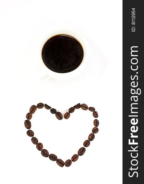 Heart made of coffee beans and a cup of coffee isolated at the white background