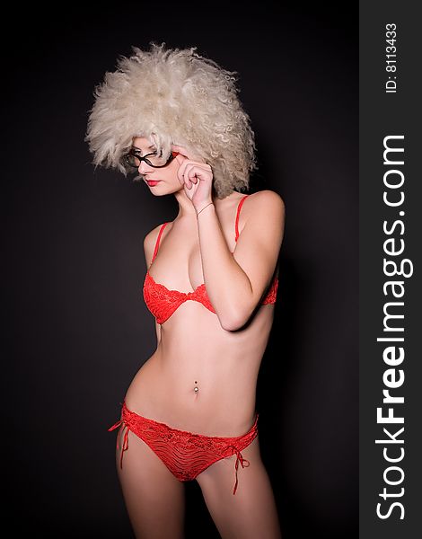 Beautiful girl in glasses and furry hat over black background