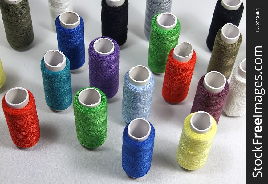 A lot of varicoloured spools is with threads. A lot of varicoloured spools is with threads