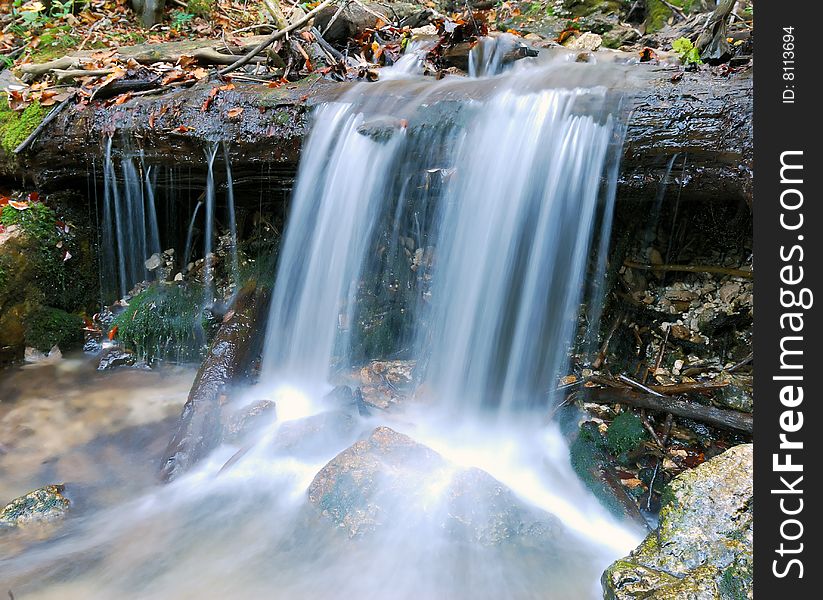 Beautiful autumn waterfall between rocks