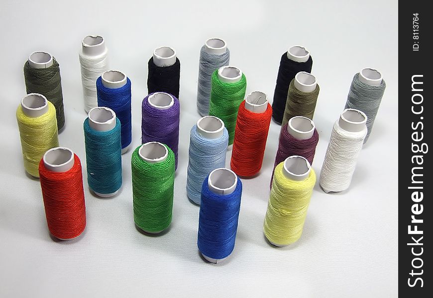 A lot of varicoloured spools is with threads. A lot of varicoloured spools is with threads