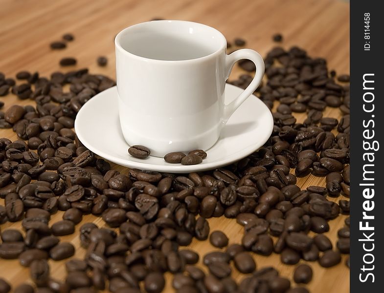 Espresso Coffee Beans with cup and saucer on wood tabletop
