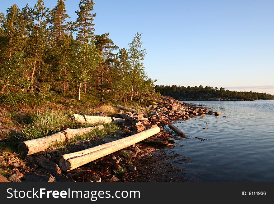 Summer sunrise with forest, water and rocks