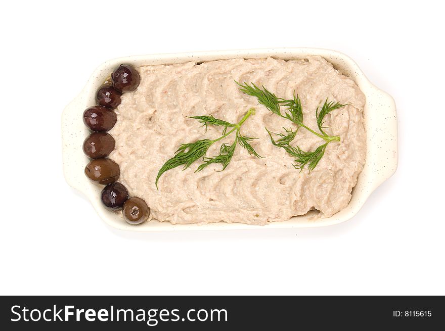 Fish cream salad on a plate with olives and dill isolated on white
