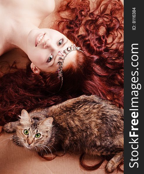 Young beautiful girl with long hair lying with a cat. Young beautiful girl with long hair lying with a cat