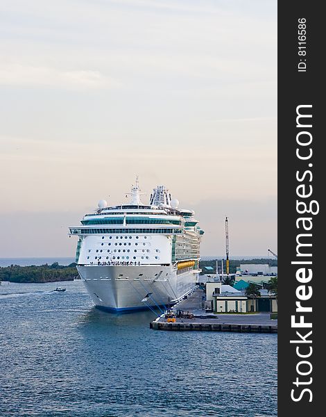 A cruise ship tied to a dock on a tropical island. A cruise ship tied to a dock on a tropical island