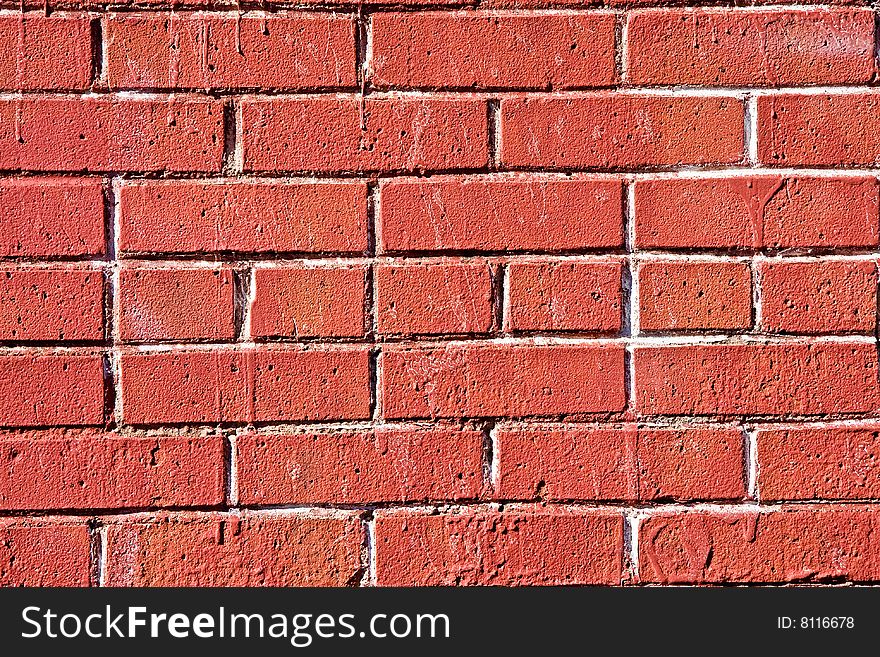 A bright red wall of worn bricks and mortar. A bright red wall of worn bricks and mortar