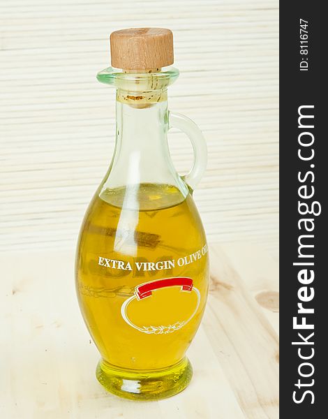 Olive oil in glass recipient on wood