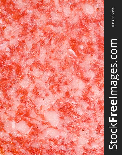 A close-up of the texture of a slice of salami. A close-up of the texture of a slice of salami