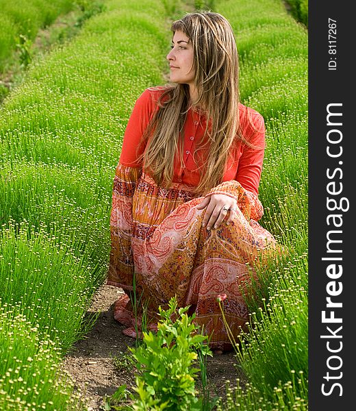 Beautiful young woman in green field looking left. Beautiful young woman in green field looking left