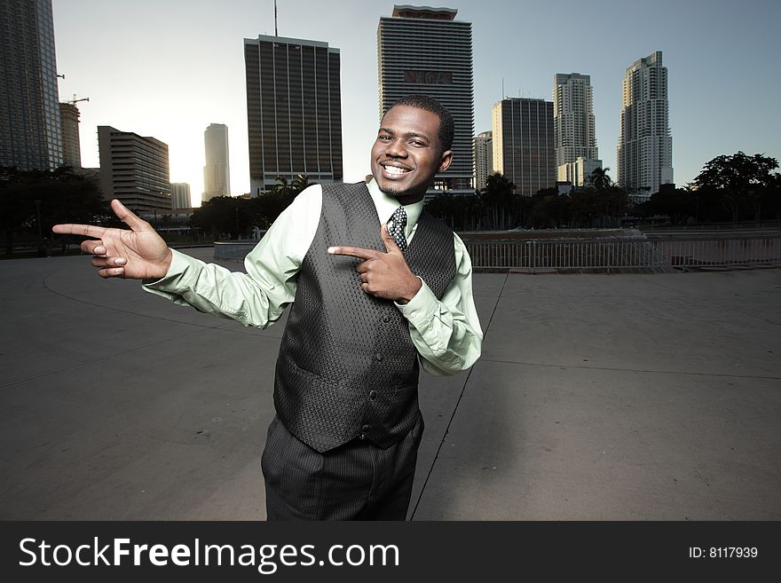 Young businessman pointing to the side and smiling. Young businessman pointing to the side and smiling