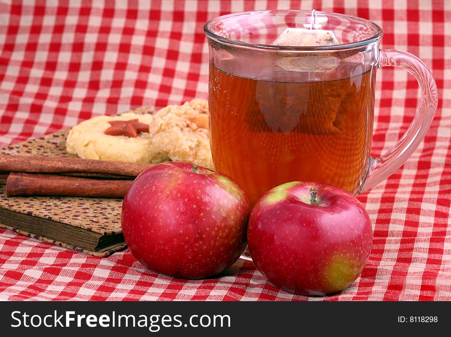 Glass of apple cinnamon tea with apples and other items