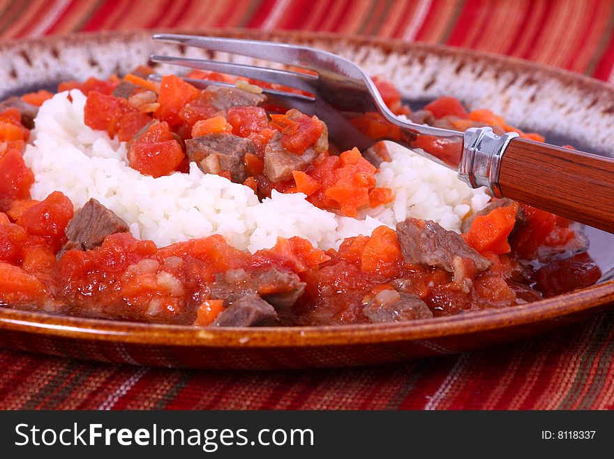 Supper of rice, meat, carrots and tomatos with a close up view. Supper of rice, meat, carrots and tomatos with a close up view